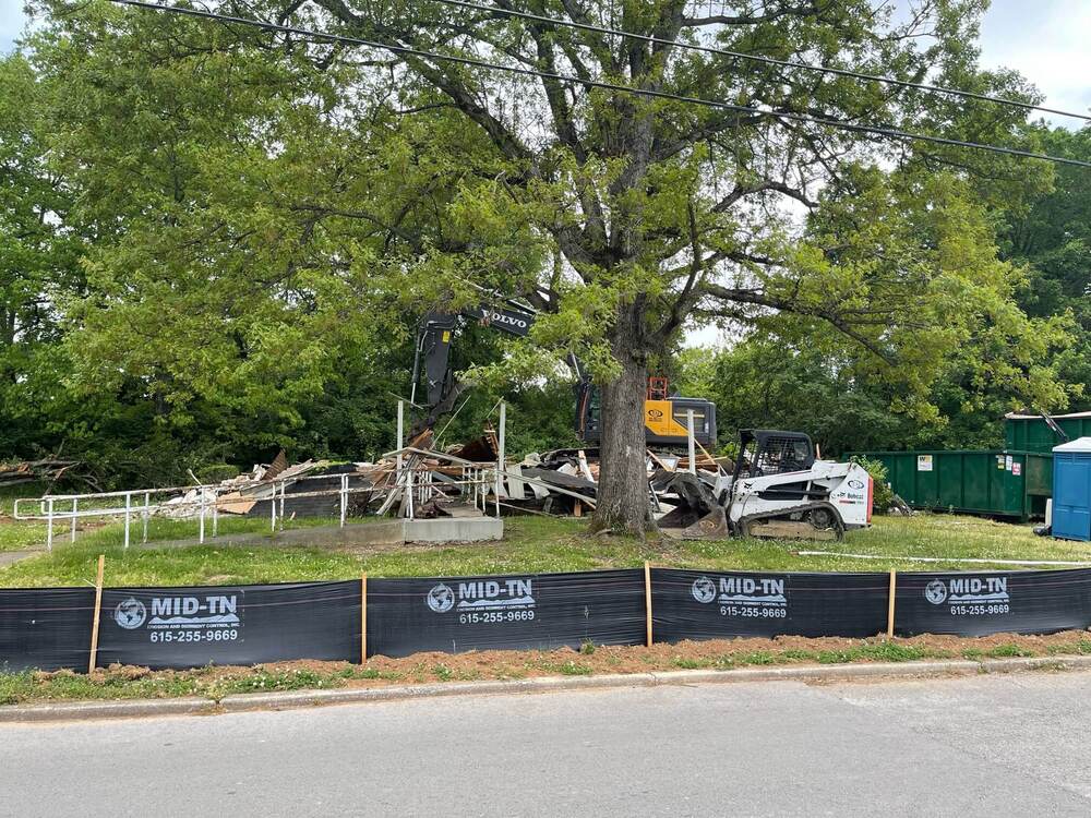 Remains of demolished home with construction equipment