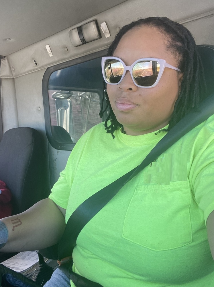 Shavallia in the drivers seat wearing sunglasses